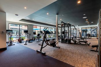 A gym with exercise equipment and large windows